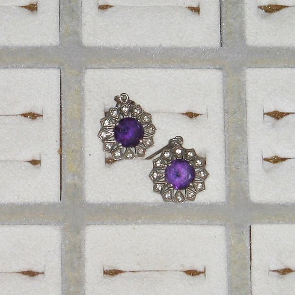 silberner Ohrschmuck mit violetten Steinen