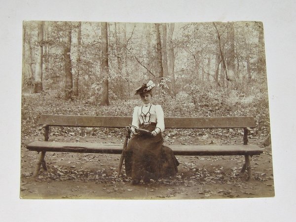Foto "Junge Frau mit Hut auf einer Parkbank" ~ um 1900